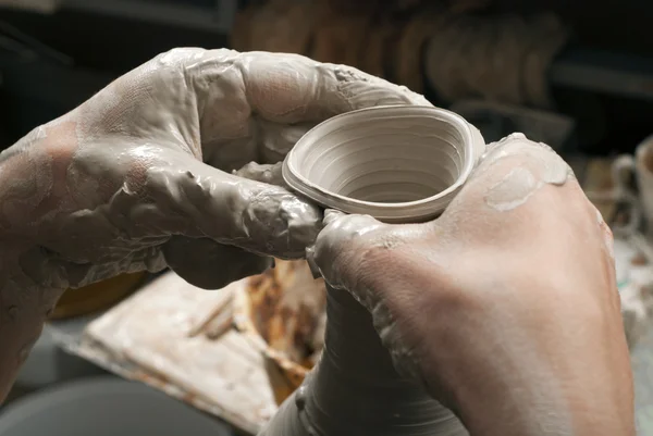 Mãos de um oleiro, criando um jarro de barro no círculo — Fotografia de Stock