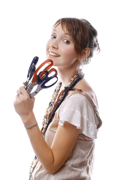 Joven chica sonriente sostiene en su mano tijeras —  Fotos de Stock