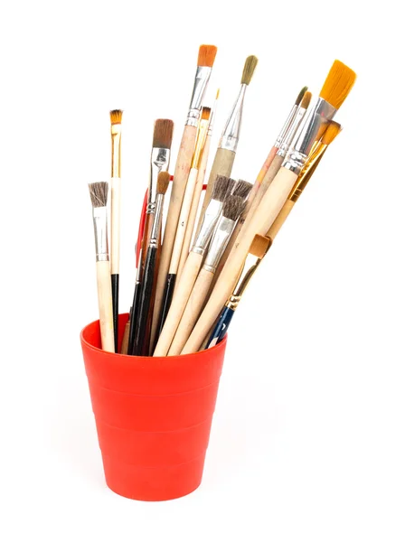 Paint brushes in red glass — Stock Photo, Image