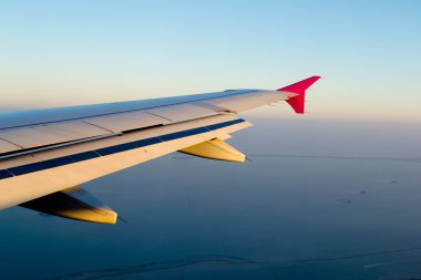 View of jet plane wing with cloud patterns clipart