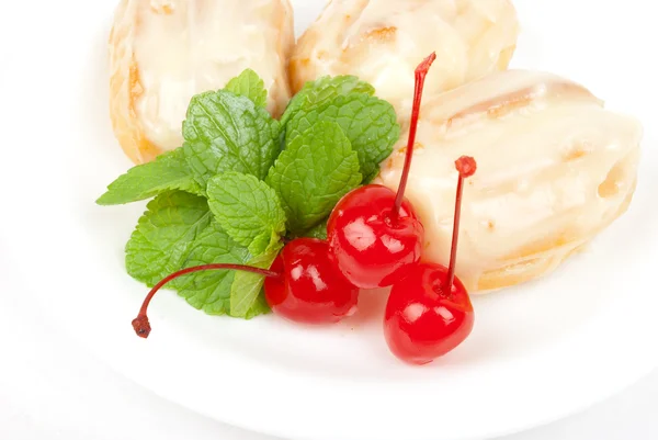 Eclairs with a cherry and mint — Stock Photo, Image