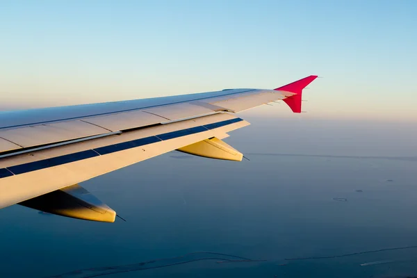 Weergave van jet vliegtuig vleugel met wolk patronen — Stockfoto