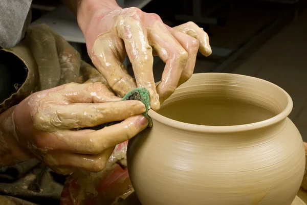 Handen van een pottenbakker, maken een aarden pot van witte klei — Stockfoto