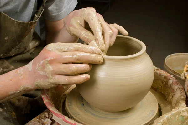 Mãos de um oleiro, criando um jarro de barro branco — Fotografia de Stock
