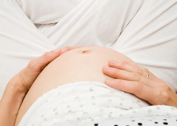 Imagen de una mujer embarazada tocándose el vientre con las manos —  Fotos de Stock
