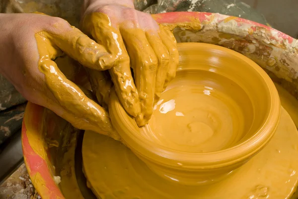 Hands of a potter, creating an earthen jar of yellow clay — Stock Photo, Image