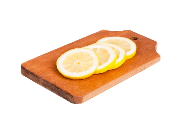 Шматочки лимона на дерев'яній обробній дошці ізольовані на білому — стокове фото