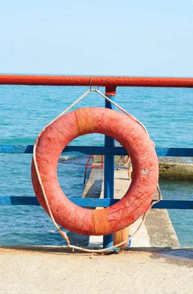 Mavi deniz önünde kırmızı lifebuoy — Stok fotoğraf