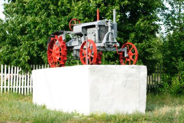 Beyaz bir pedestal.ukraine üzerinde eski bir traktör. Poltava bölge.