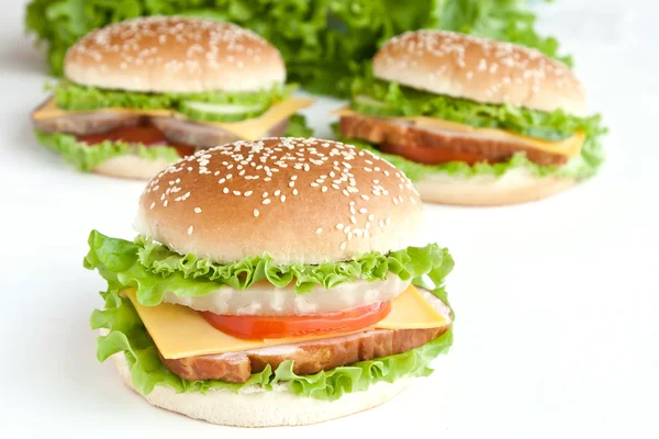 Három burger hússal és zöldséggel — Stock Fotó