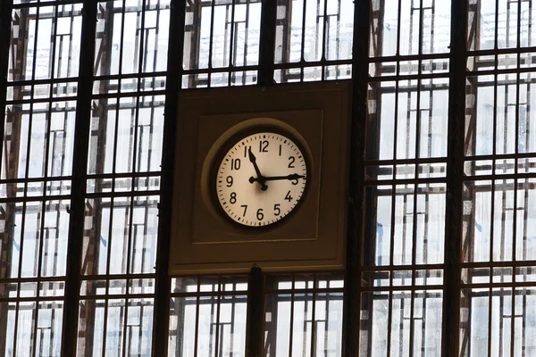 stock image A big watch on wall from windows with lines