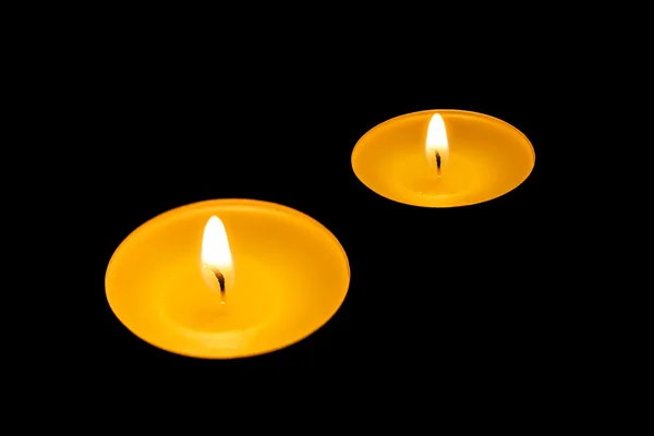 Dos velas encendidas sobre un fondo negro — Foto de Stock