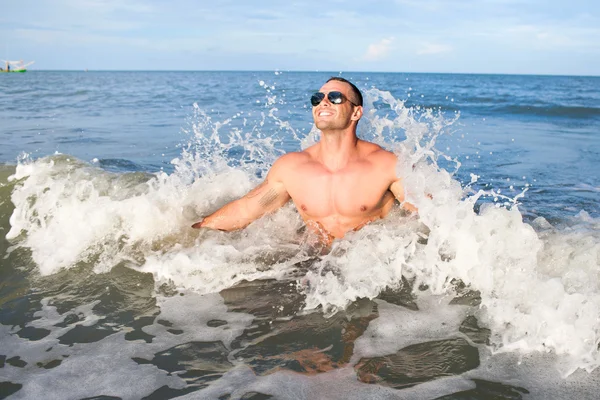 Счастливый мускулистый мужчина наслаждается морем — стоковое фото