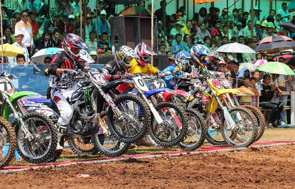 Motocross riders lined up at the start gate
