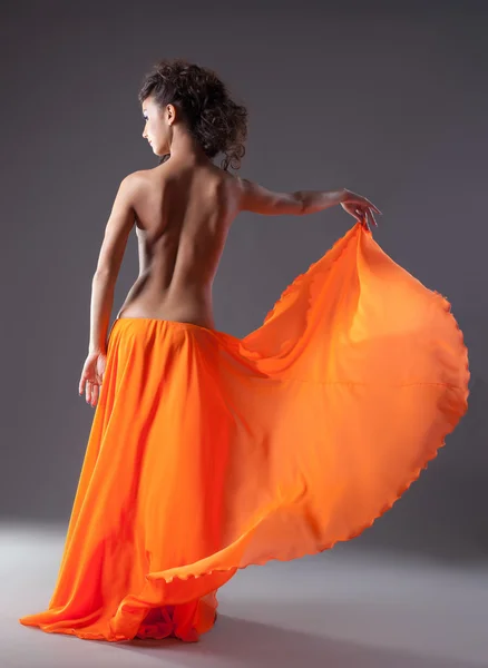 Frau tanzt in orangefarbenem Schleier mit nacktem Rücken — Stockfoto