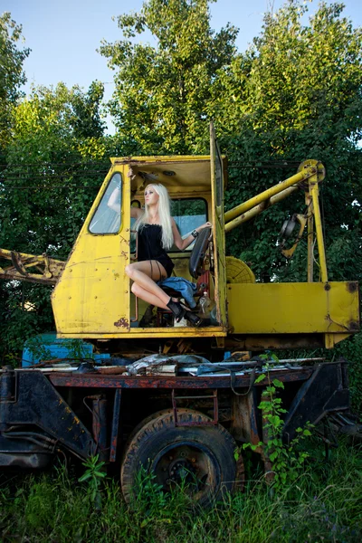 Traktör içinde oturan sarışın genç kadın — Stok fotoğraf