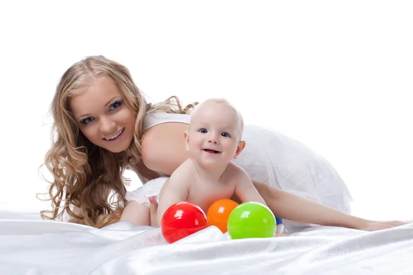Smiling mother and baby in bed — Stock Photo, Image