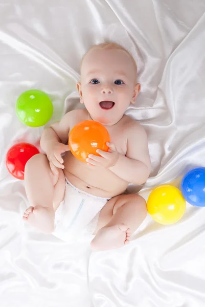 Happy baby with colored balls — Stock Photo, Image