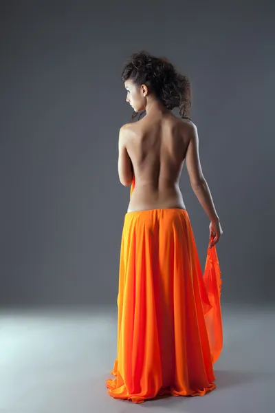 Schöne junge Frau im langen orangefarbenen Rock — Stockfoto