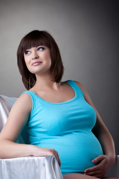 Szczęśliwa kobieta w ciąży w studio — Zdjęcie stockowe