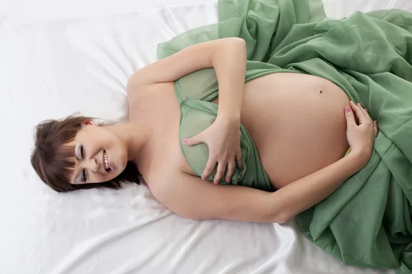 Mujer embarazada feliz acostada en la cama —  Fotos de Stock