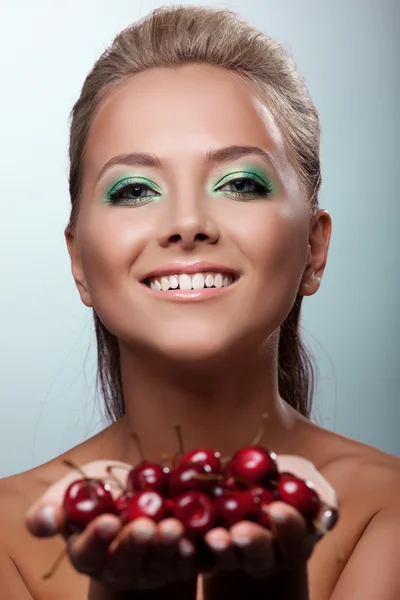 Hymyile nainen tarjota makusi kypsä kirsikka — kuvapankkivalokuva