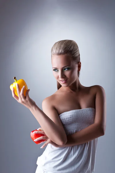 Kaunis nuori nainen pitää kaksi bulgarialaista pippuria — kuvapankkivalokuva