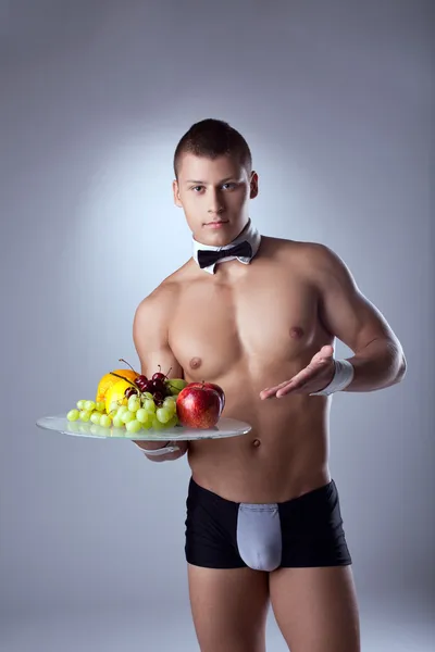 Muscular man waiter offer fruits — Stock Photo, Image