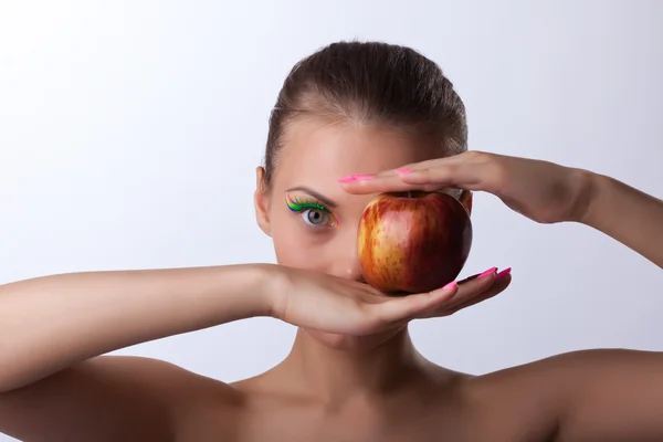 Kaunis nainen punainen omena lähellä puoli kasvot — kuvapankkivalokuva