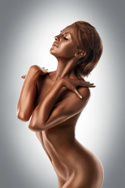 Голая женщина с металлической кожей, позирующая как статуя — стоковое фото