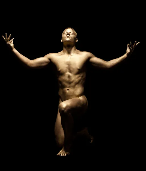 Homme fort posant nu dans l'obscurité avec la peau d'or — Photo