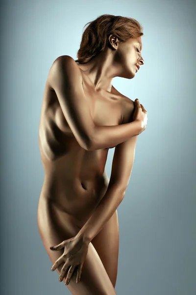 Sexy jonge vrouw portret poseren met gouden huid — Stockfoto