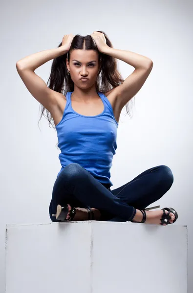 Sexy brunette sit in jeans and blue tank top — Stock Photo, Image