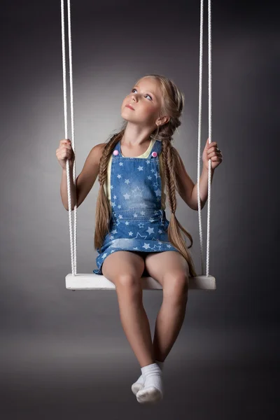 Piękna dziewczyna siedzi na swing — Zdjęcie stockowe