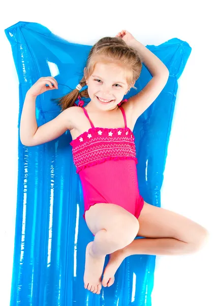 Linda niña en un traje de baño en un colchón inflable —  Fotos de Stock