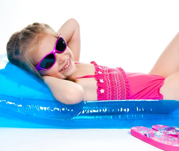 एक inflatable चटई वर जलतरण सूट मध्ये सुंदर लहान मुलगी — स्टॉक फोटो, इमेज