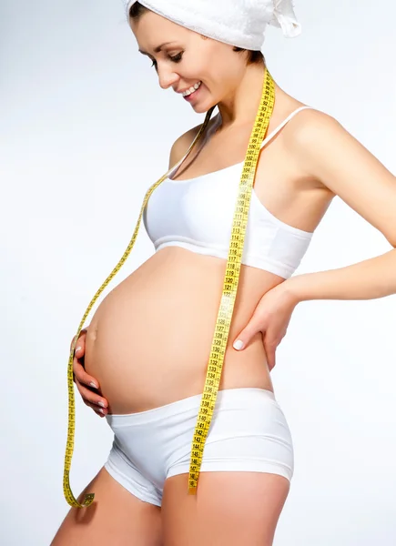 Zwangere vrouw maatregelen haar maag Stockfoto