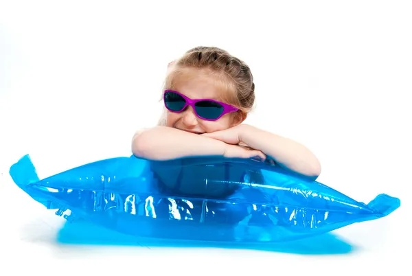 Menina bonito em um terno de natação em um colchão inflável — Fotografia de Stock