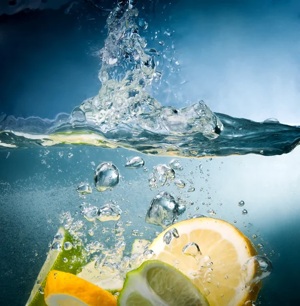 Cítricos caen al agua — Foto de Stock