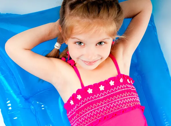 Cute little girl in a swimming suit on an inflatable mattress — Stock Photo, Image
