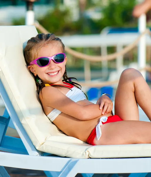 Little girl lies on a chaise lounge — Stock Photo, Image