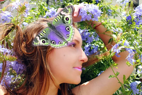 Beautiful woman with butterfly in the garden — Stock Photo, Image