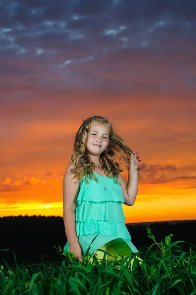 Szczęśliwa młoda dziewczyna odpoczywa na zielonym polu po burzy — Zdjęcie stockowe