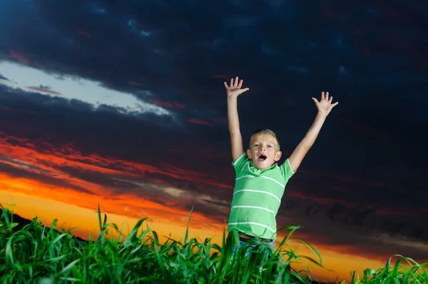 Foto eines kleinen Jungen, der draußen die Hände hebt — Stockfoto