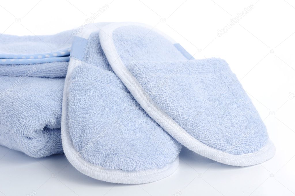 Blue slippers, towel and bath & shower mitt isolated on white