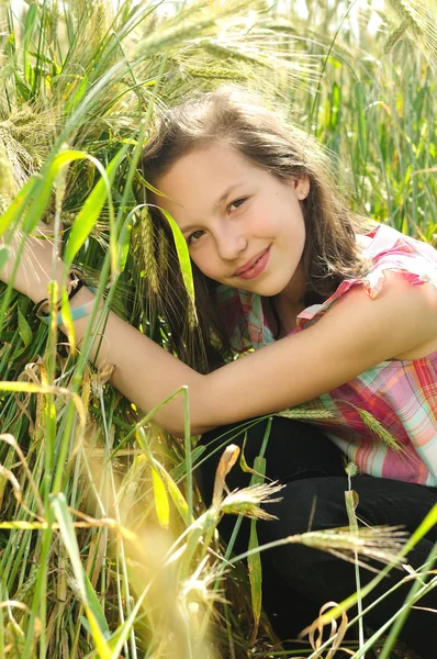 Jovem menina bonita em um campo de trigo — Fotografia de Stock