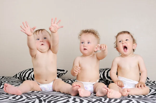 Um grupo de belos bebês sentados dentro de casa — Fotografia de Stock