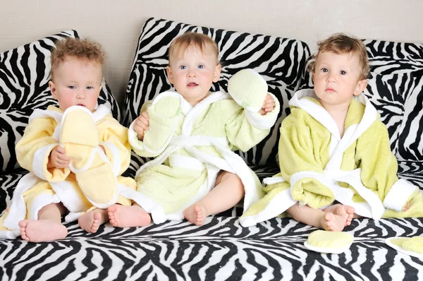 Um grupo de belos bebês sentados dentro de casa — Fotografia de Stock