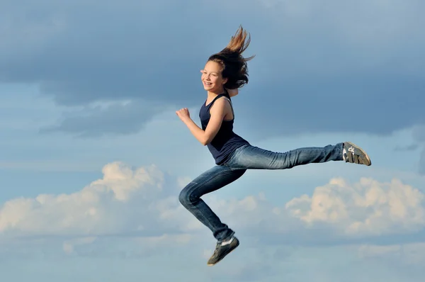 Schönes Mädchen im Turnsprung gegen blauen Himmel — Stockfoto