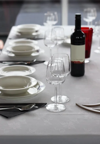 Table setting with plates and wine glasses — Stock Photo, Image